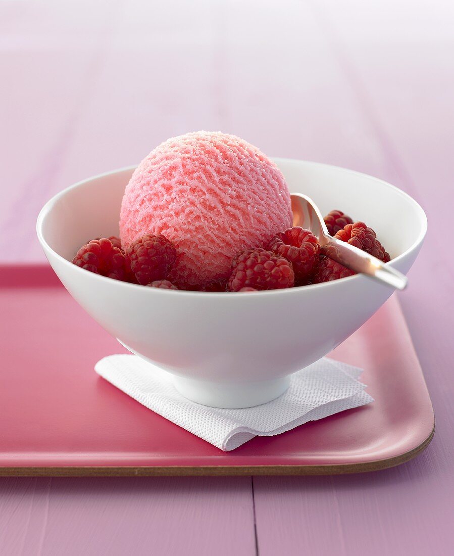 Raspberry ice cream and fresh raspberries in a bowl