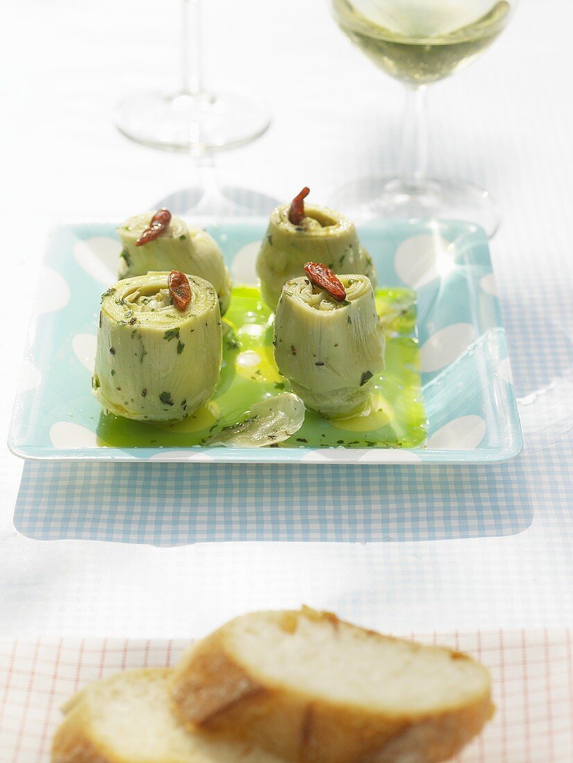 Pickled artichoke hearts, glass of white wine, white bread