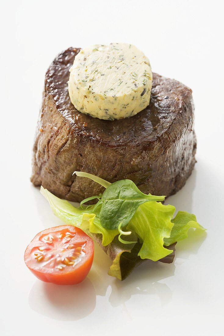 Beef fillet steak with herb butter, tomato, salad leaves