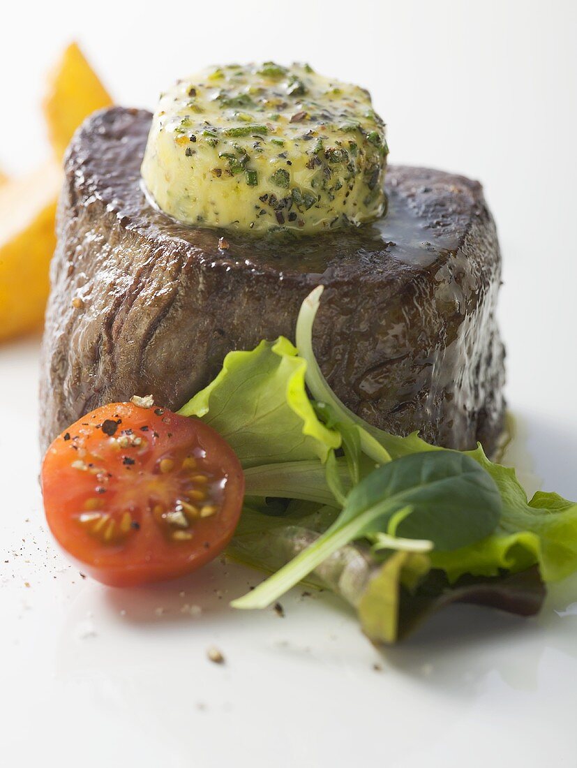 Beef fillet with herb butter, tomato and salad garnish