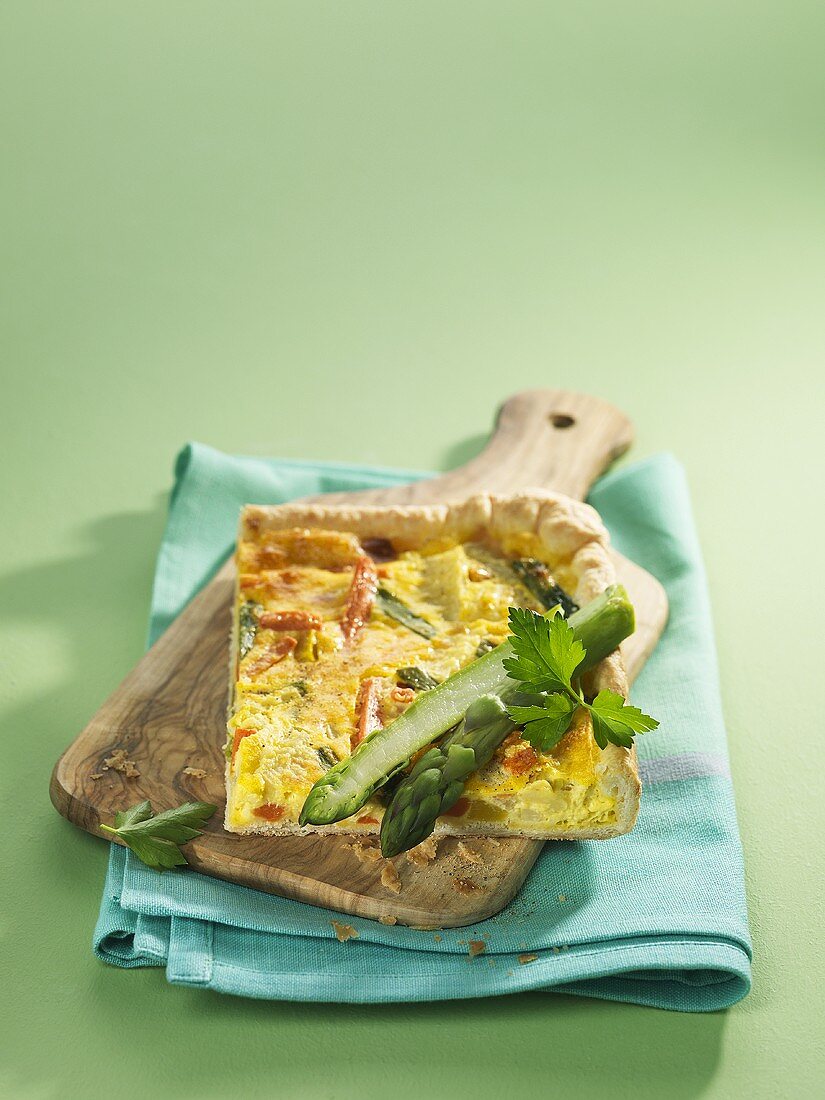 Quiche mit Frühlingsgemüse auf Schneidebrett