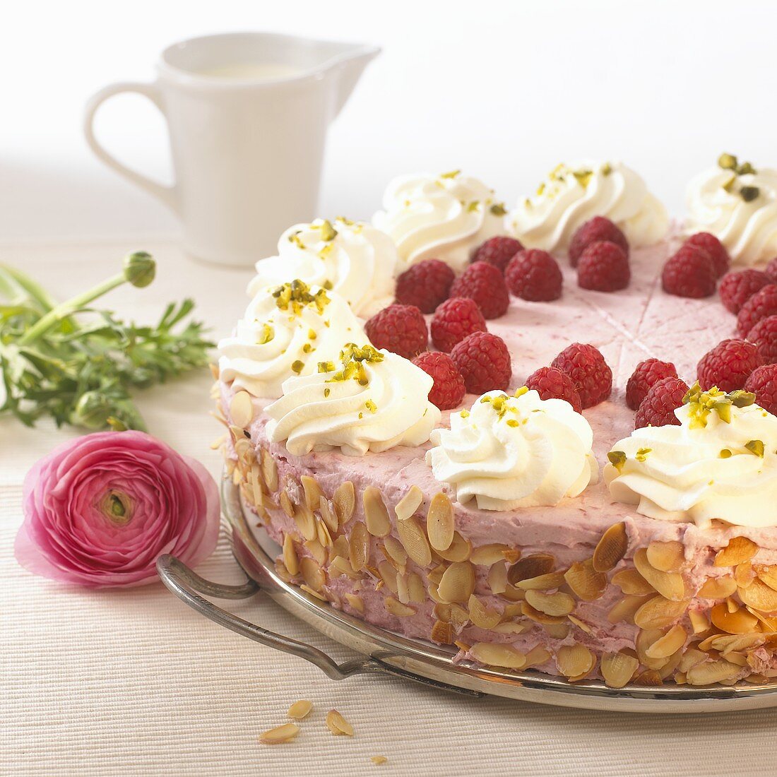 Raspberry cream cake with flaked almonds