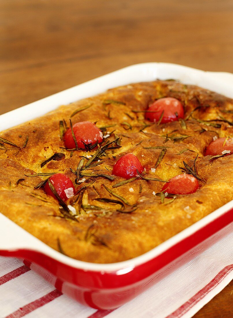 Focaccia with rosemary and tomatoes in a baking dish
