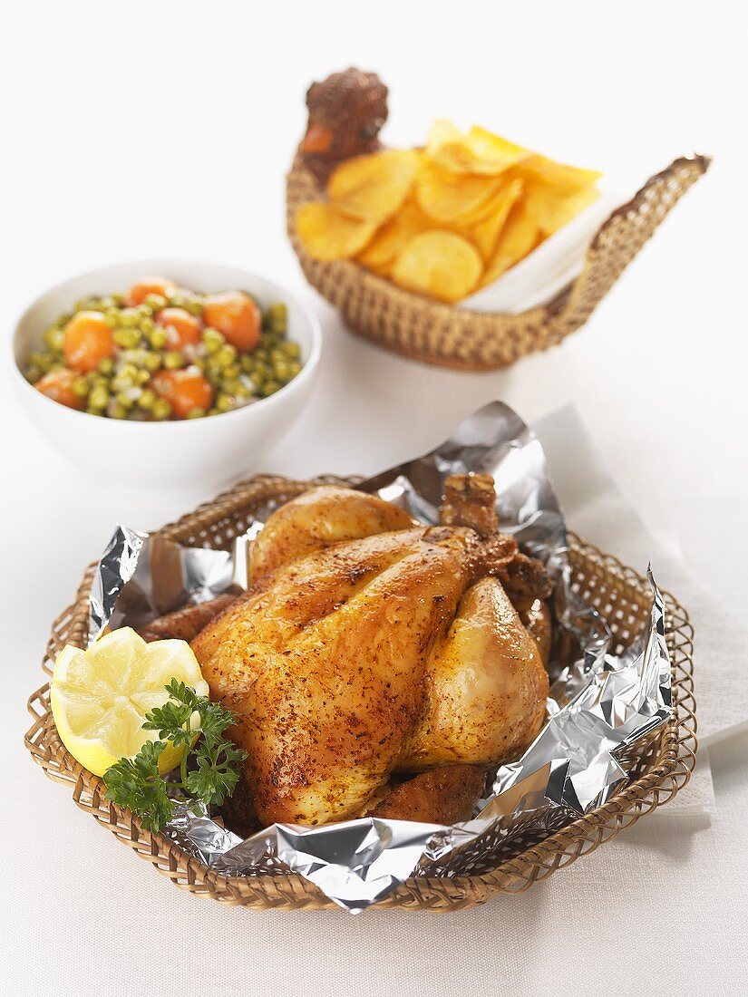 Roast chicken in a basket, mixed vegetables, potato crisps