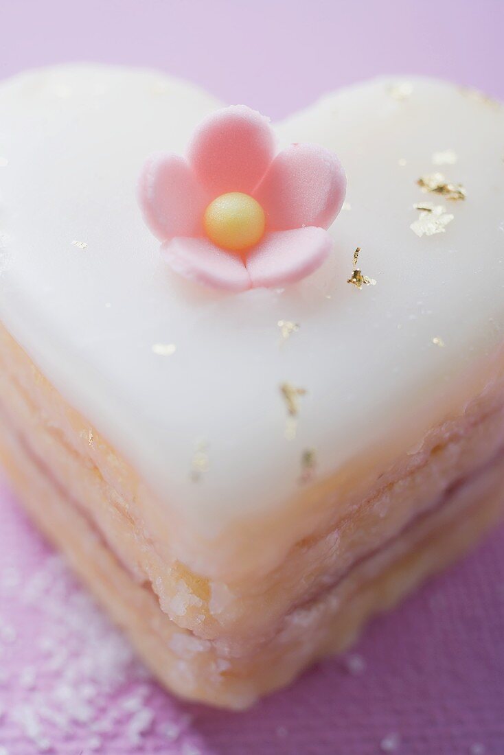 Small heart-shaped cake with sugar flower and gold leaf
