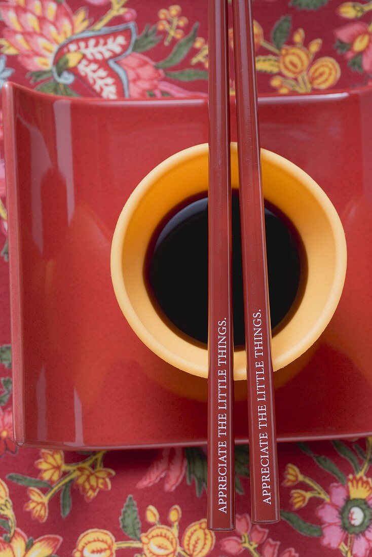 Soy sauce in small dish, chopsticks on dish