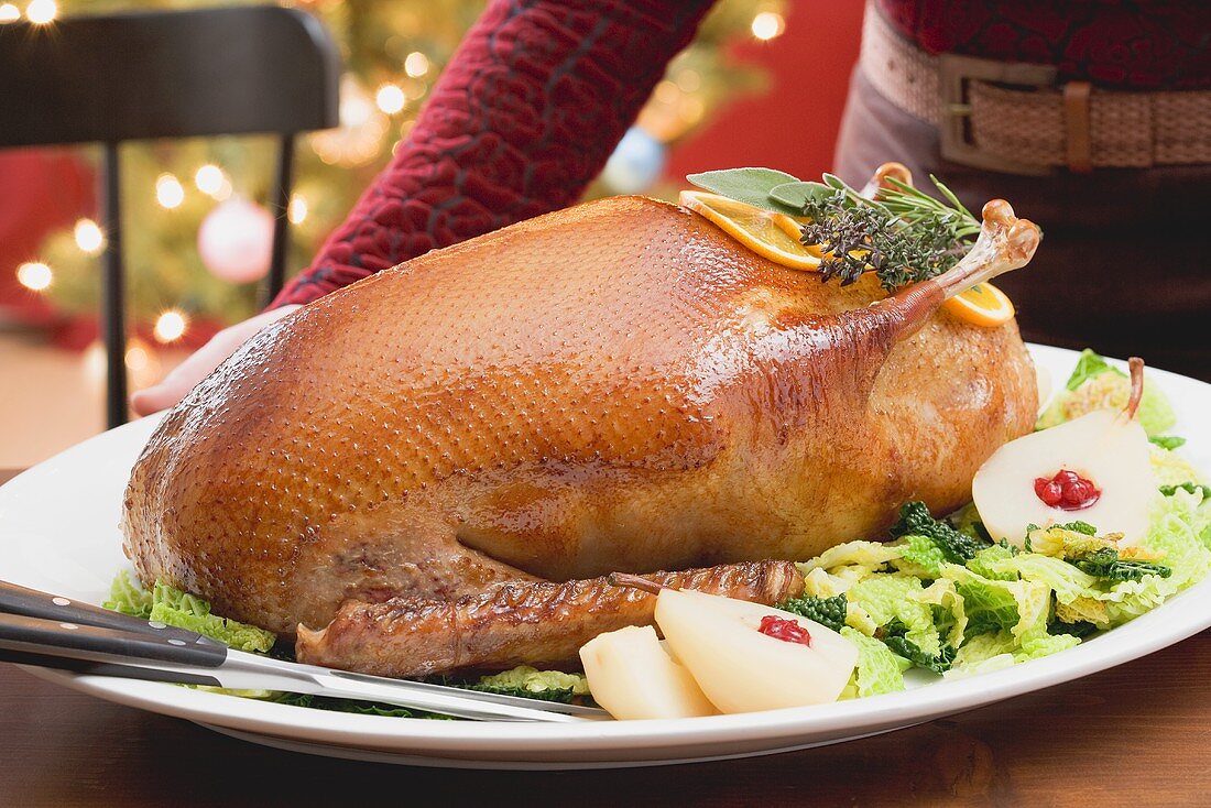 Woman serving roast duck (Christmas)