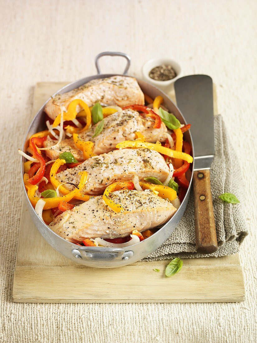 Roasted salmon fillets with peppers in roasting tin