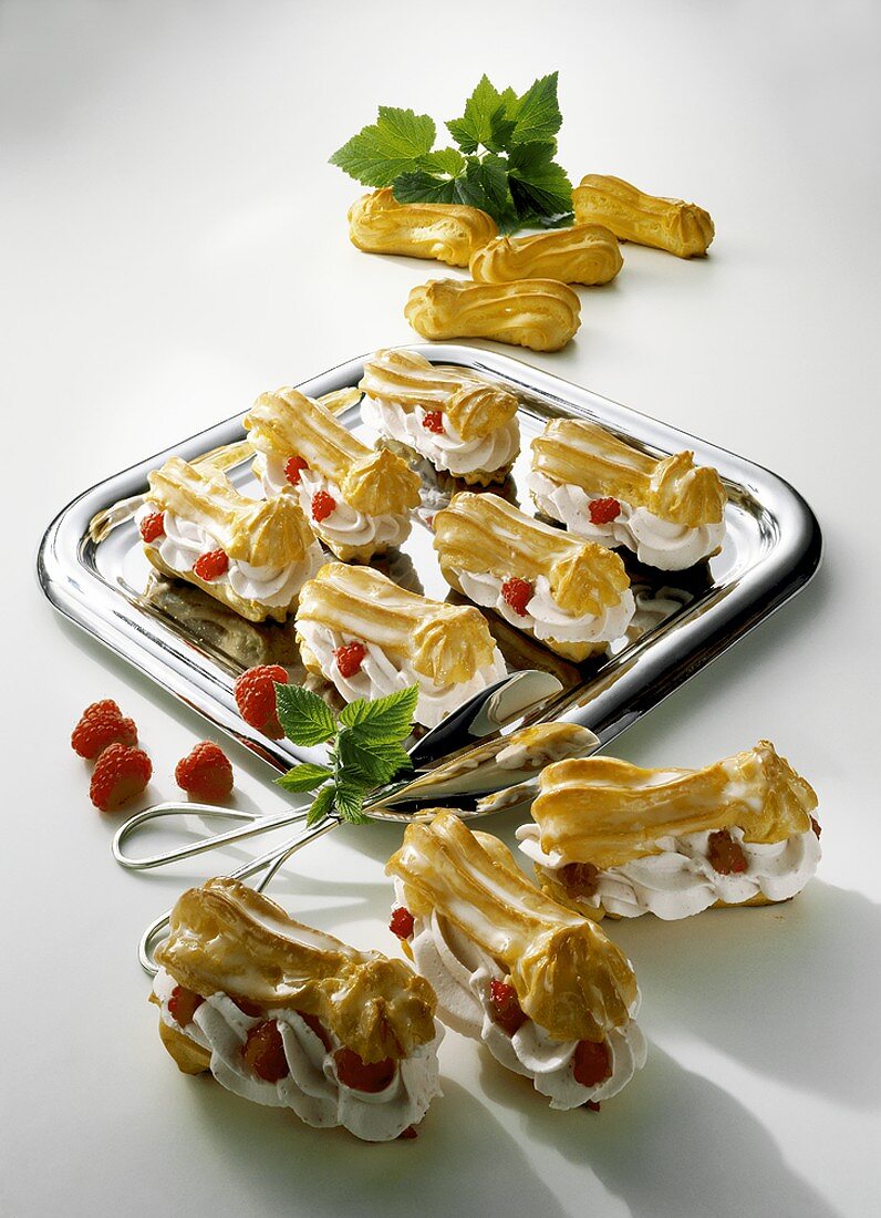 Eclairs filled with cream and raspberries