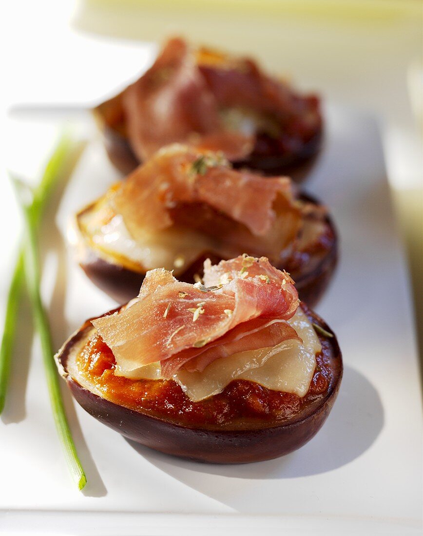 Baked stuffed aubergines topped with raw ham