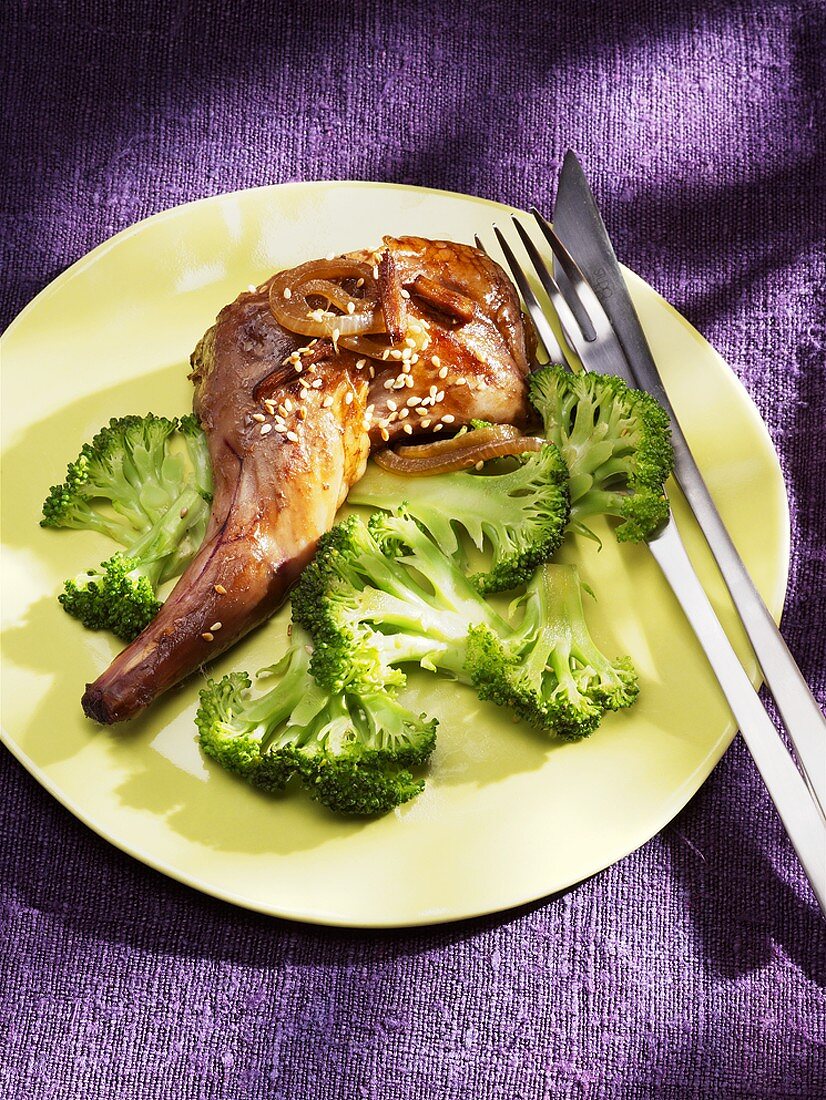 Rabbit leg with sesame seeds on broccoli