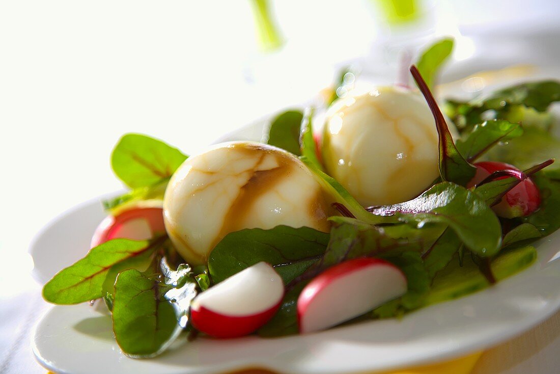 Salad leaves with marbled eggs and radishes