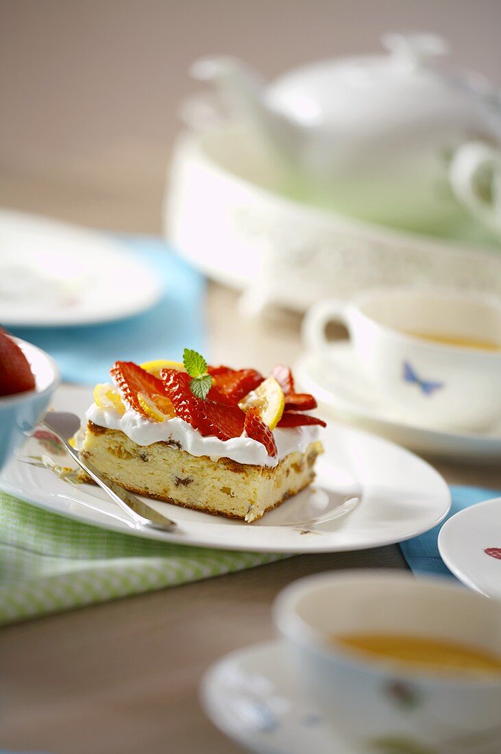 Piece of strawberry cake and cups of tea
