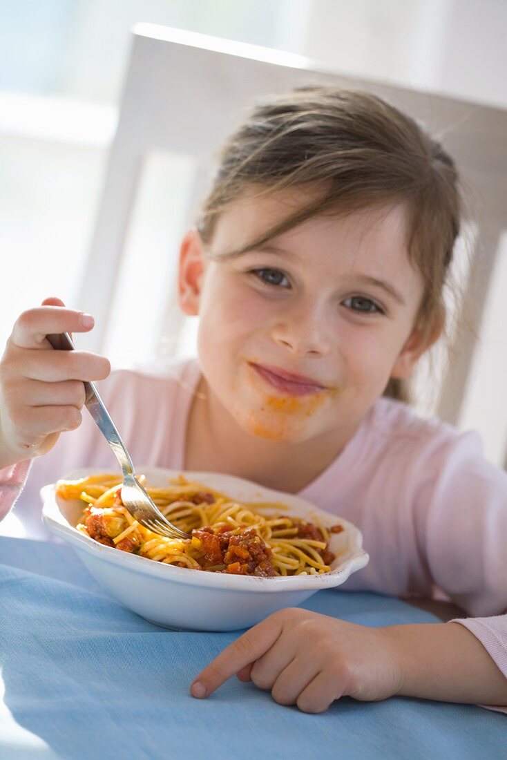 Girl eating spaghetti bolognese