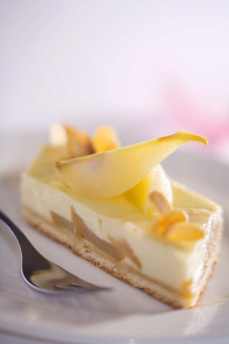 Stück Käsekuchen mit Birnen und Mandelblättchen