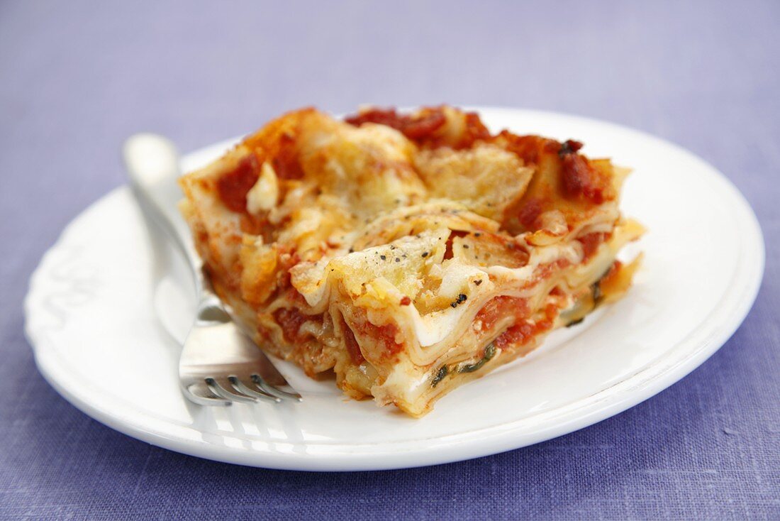 Stück Tomaten-Lasagne auf Teller