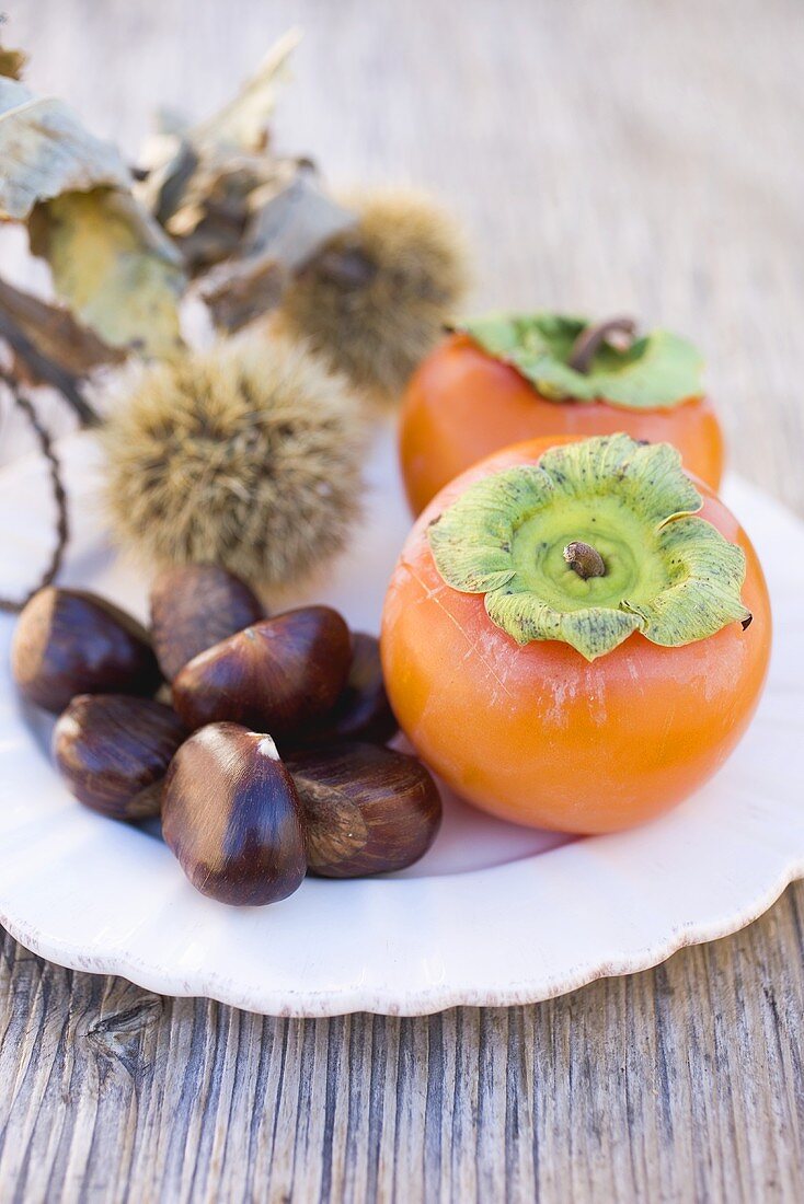 Sweet chestnuts and persimmons on plate