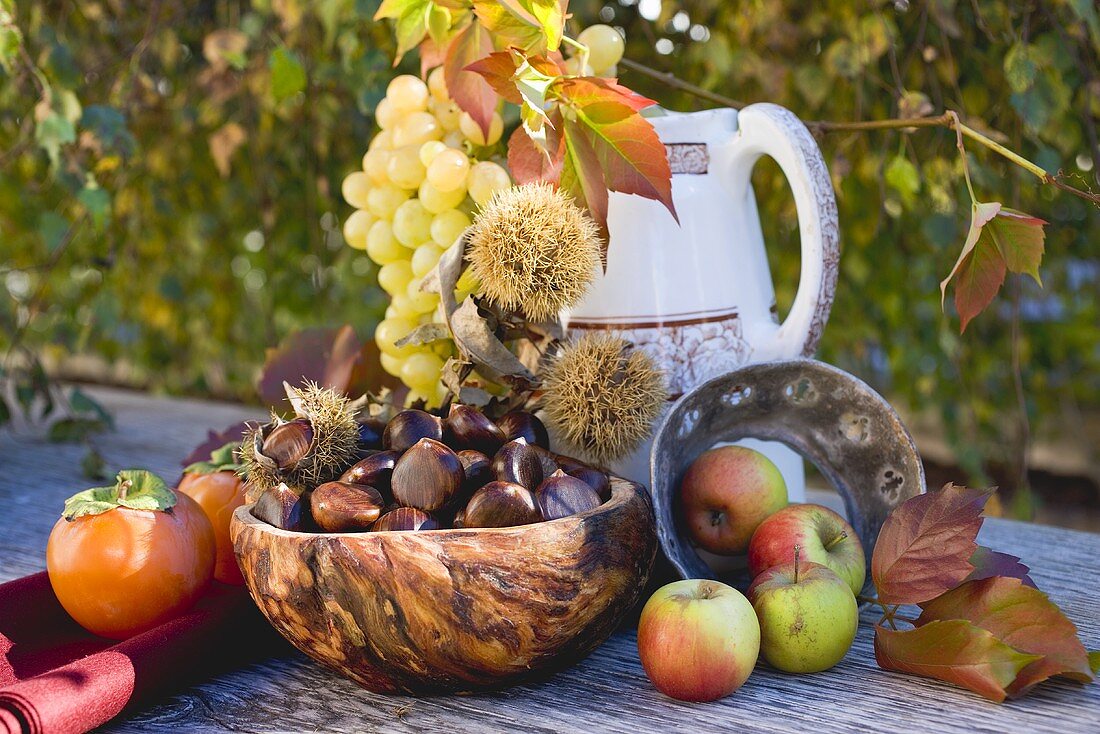 Esskastanien, Trauben, Kakis, Äpfel und Herbstlaub