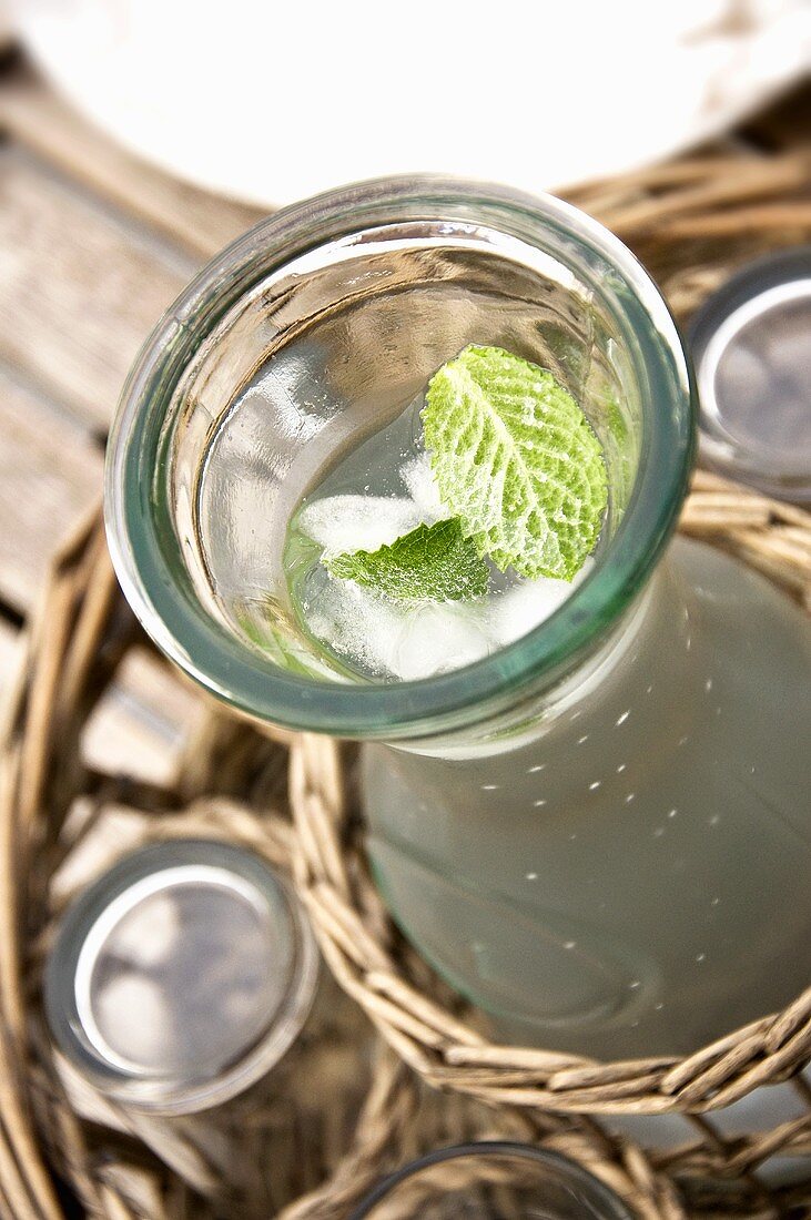 A carafe of water with mint and ice cubes
