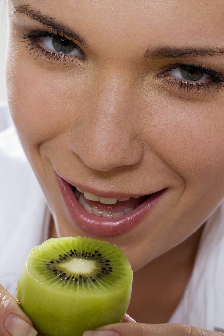 Young woman with kiwi fruit (close-up)