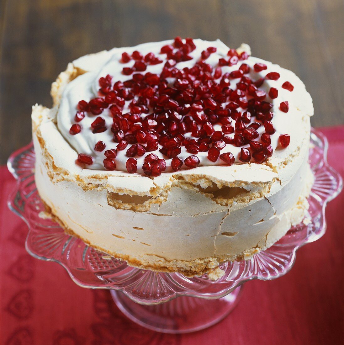 Meringue cake with cream and pomegranate seeds