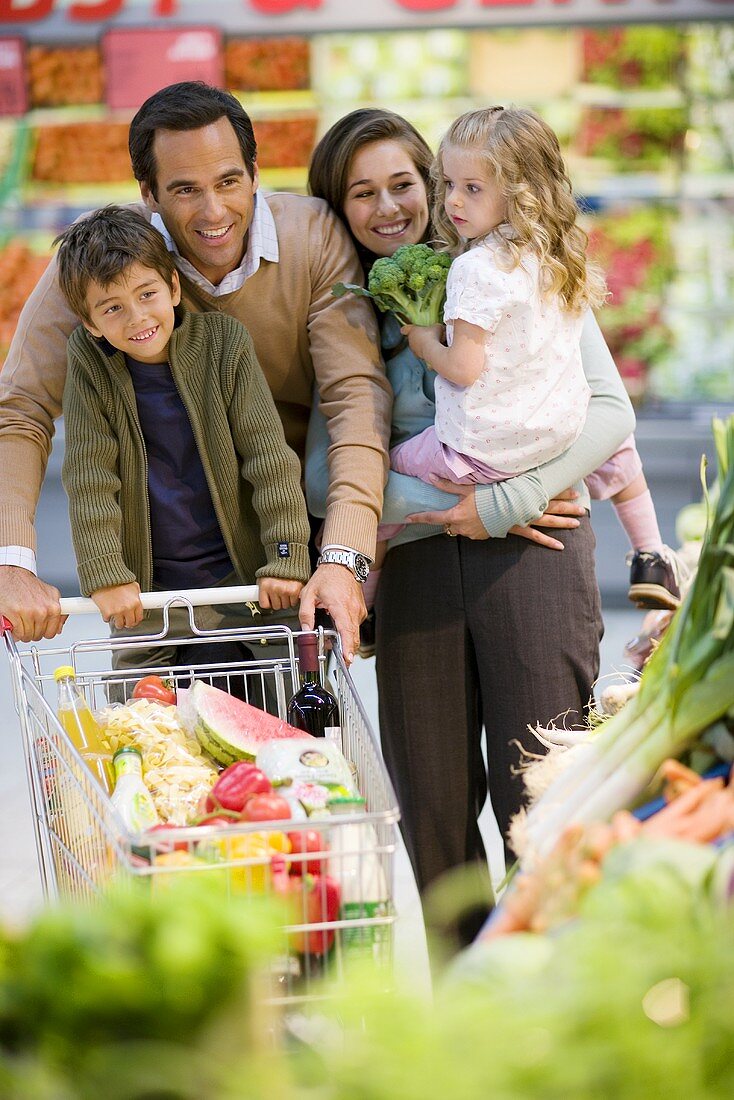 Familie mit vollem Einkaufswagen im Supermarkt