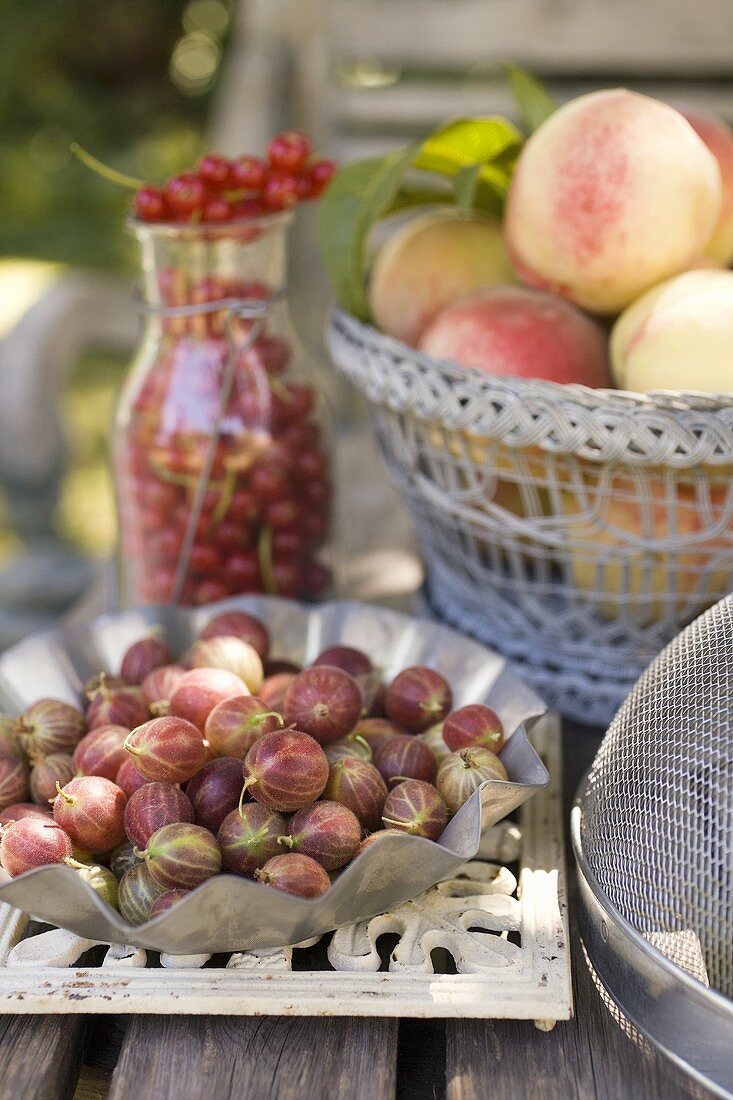 Frische Beeren und Pfirsiche auf einem Gartentisch