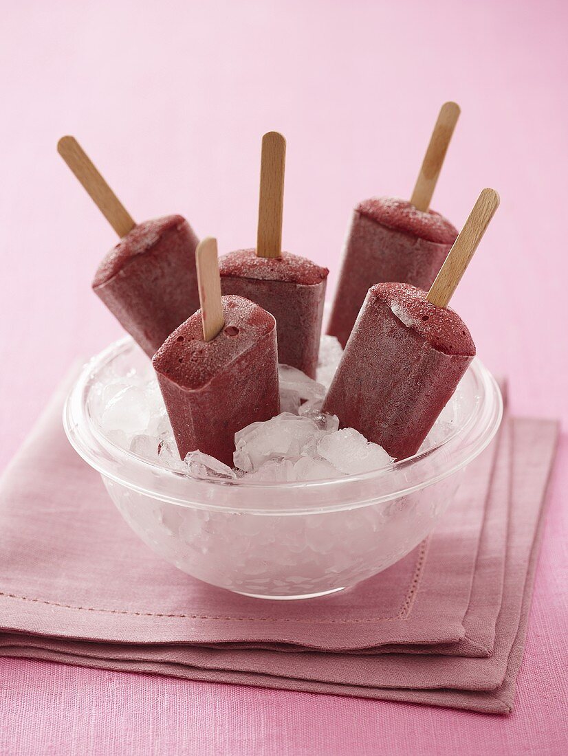 Fruit ice lollies in a bowl of ice cubes