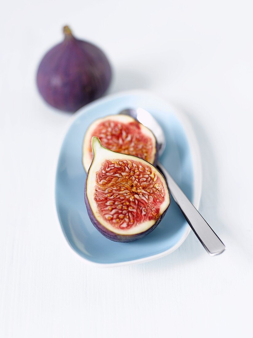 Two fig halves with spoon on plate