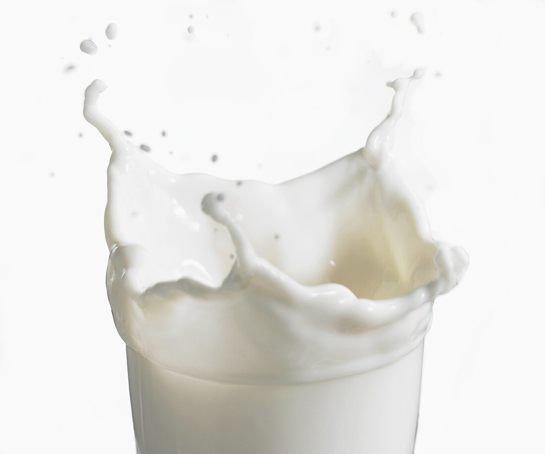 Milch spritzt aus einem Glas
