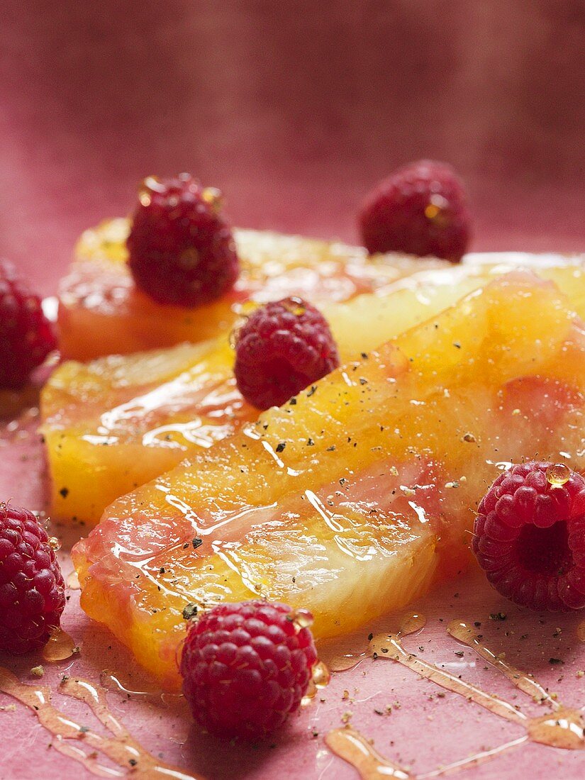 Zitrusfrüchteschnitten mit Himbeeren und Honig