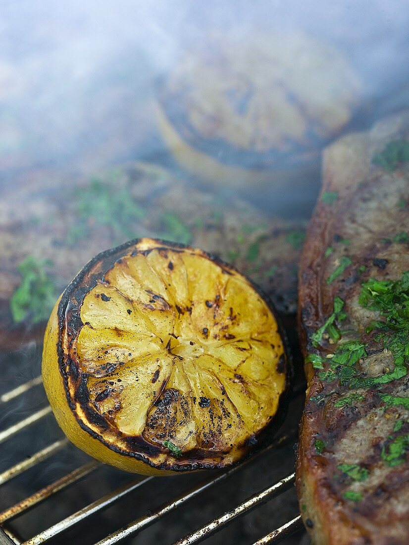 Gegrillte Zitronen und Koteletts auf dem Grillrost