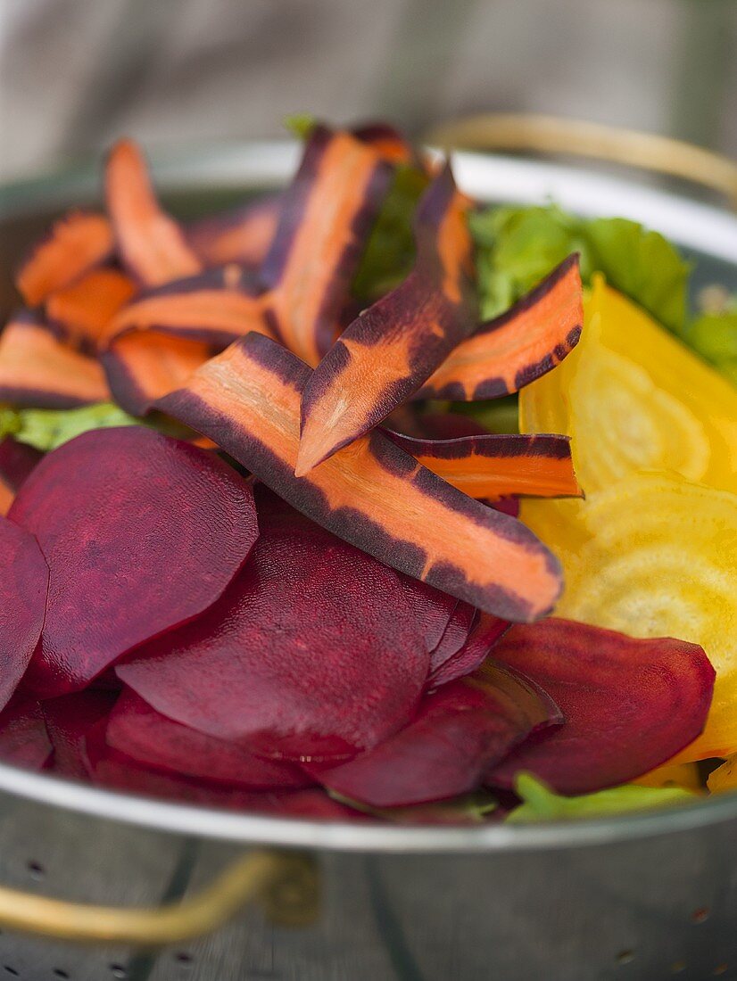 Salad ingredients in colander (beetrot, yellow beet, carrots)