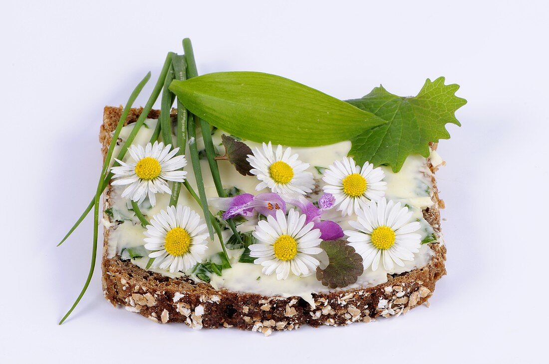 Wholemeal bread with herb butter and daisies