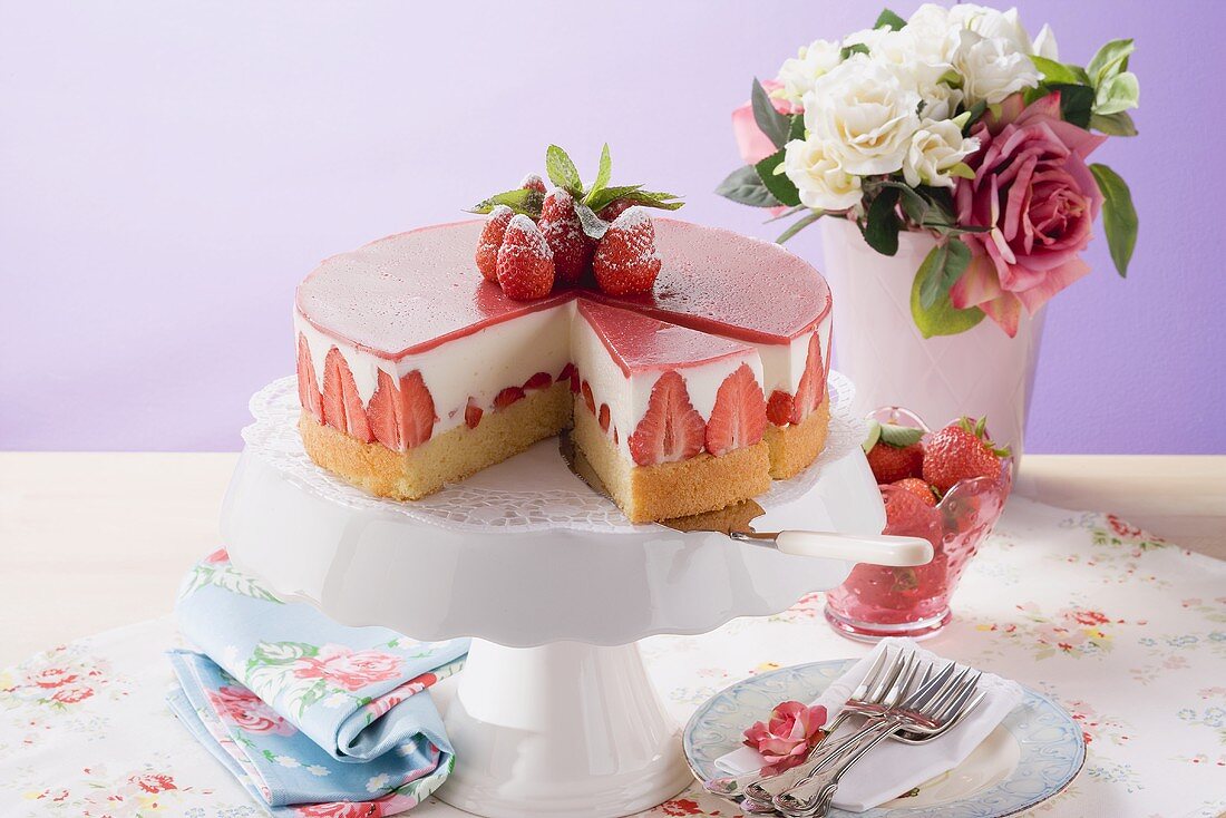 Strawberry yoghurt cake, a piece cut, on cake stand