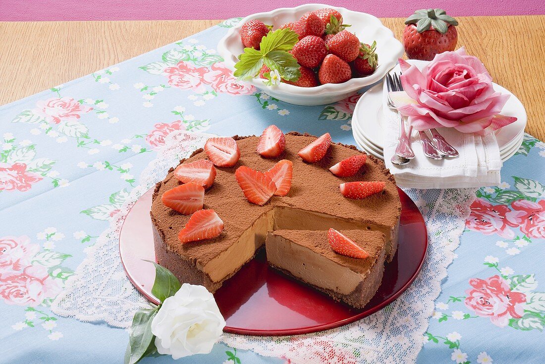 Schokoladenkäsekuchen mit Erdbeeren und Kakaopulver