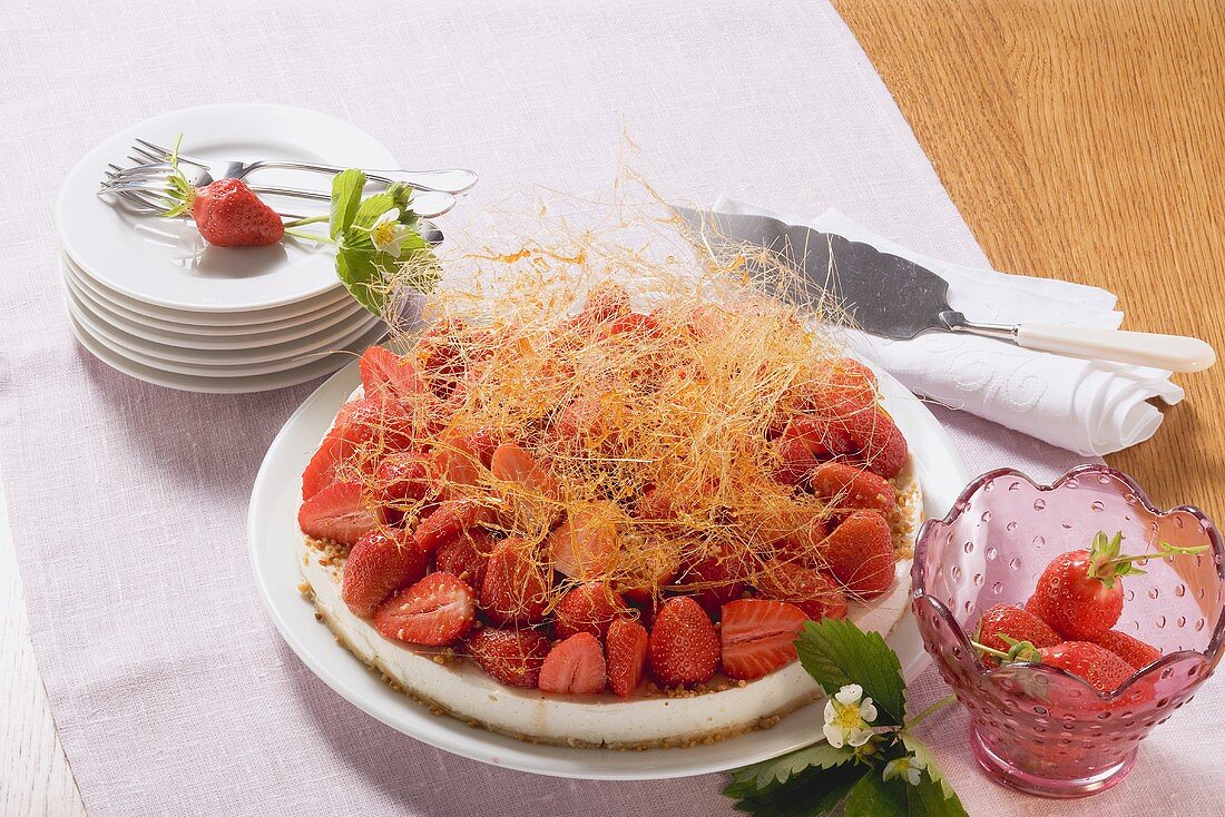 Käsekuchen mit Erdbeeren und Karamellfäden