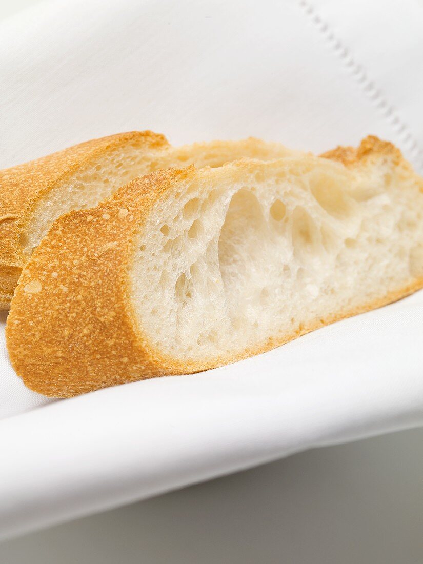 Two baguette slices on white fabric napkin