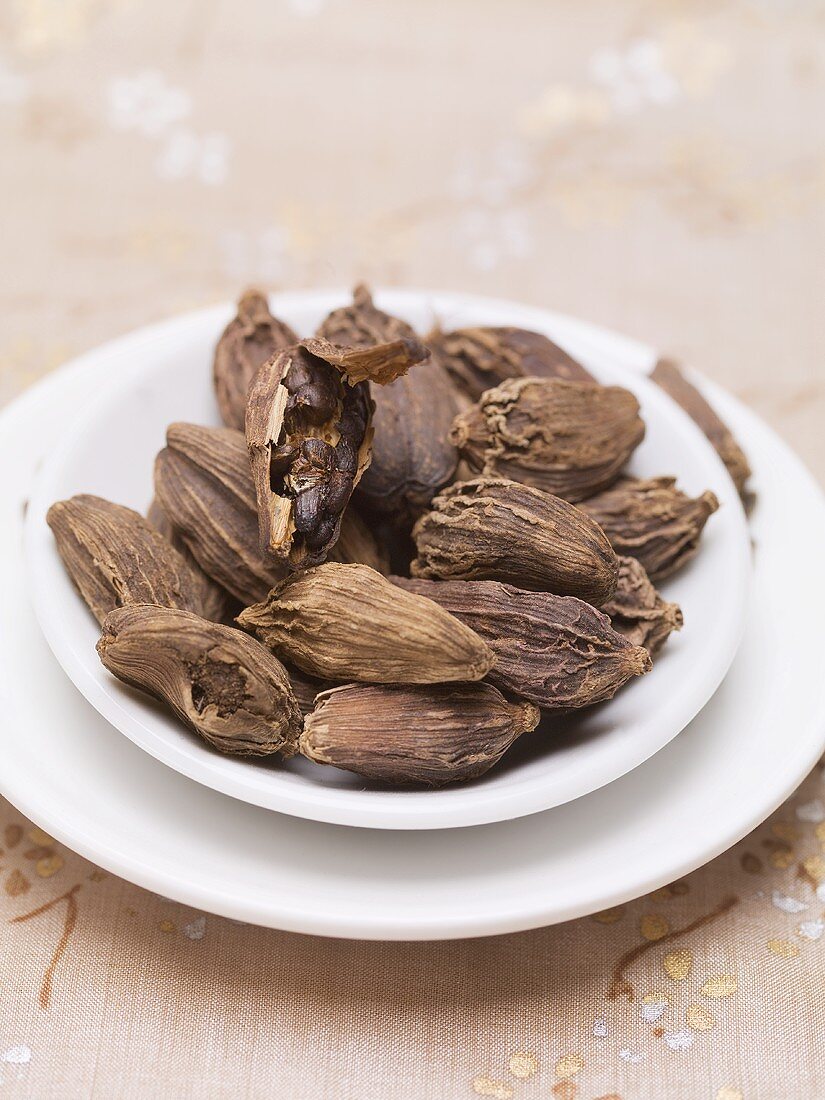 Dried black cardamom pods on plate