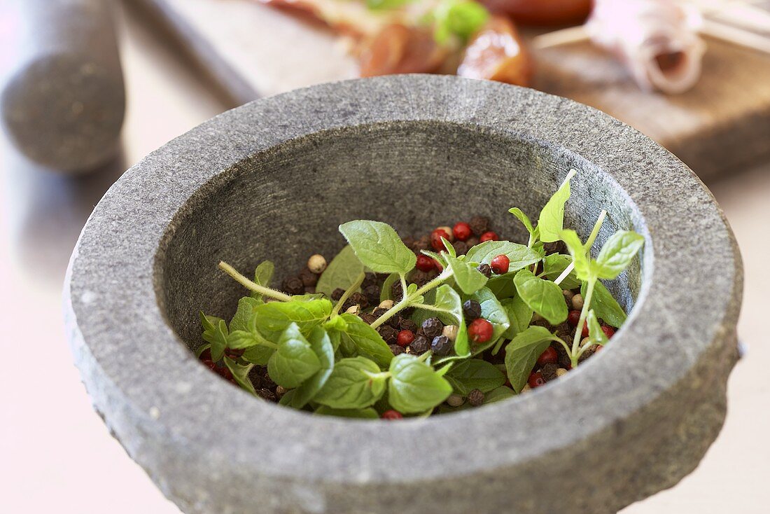 Peppercorns and herbs in mortar