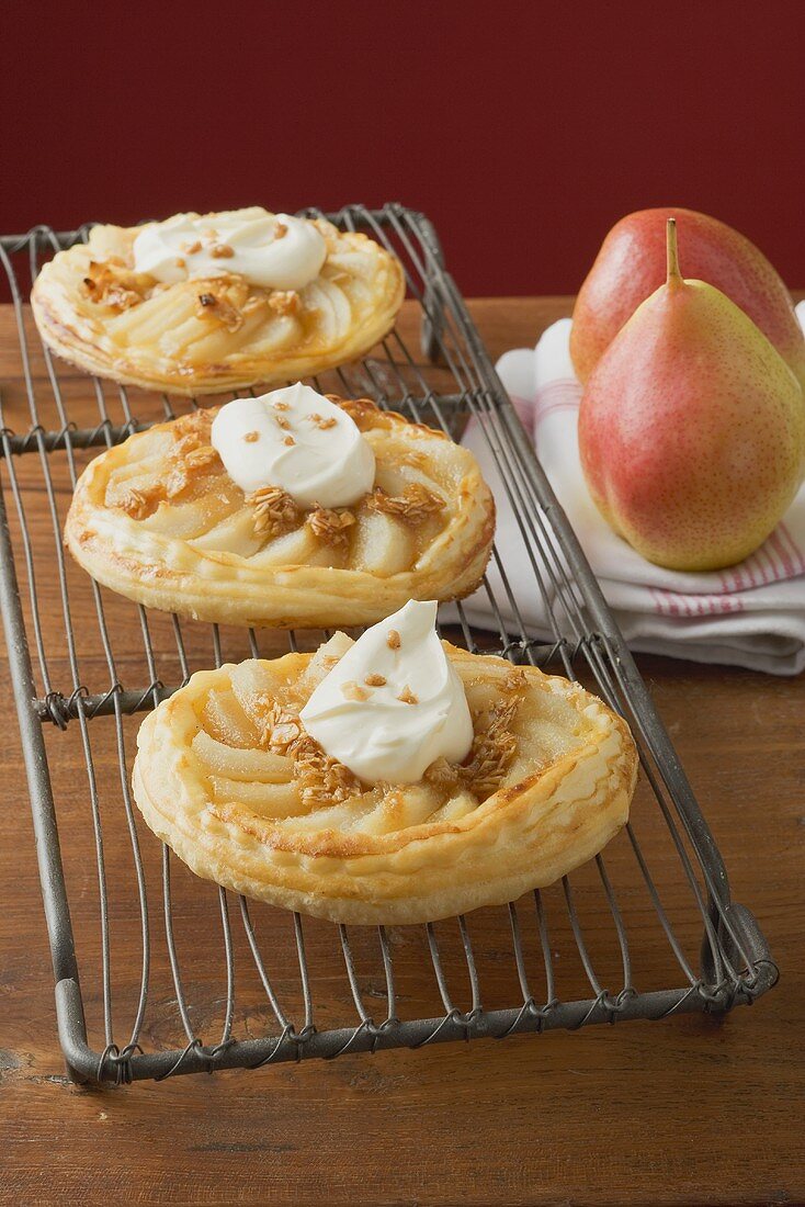 Pear tartlets with cream on cake rack