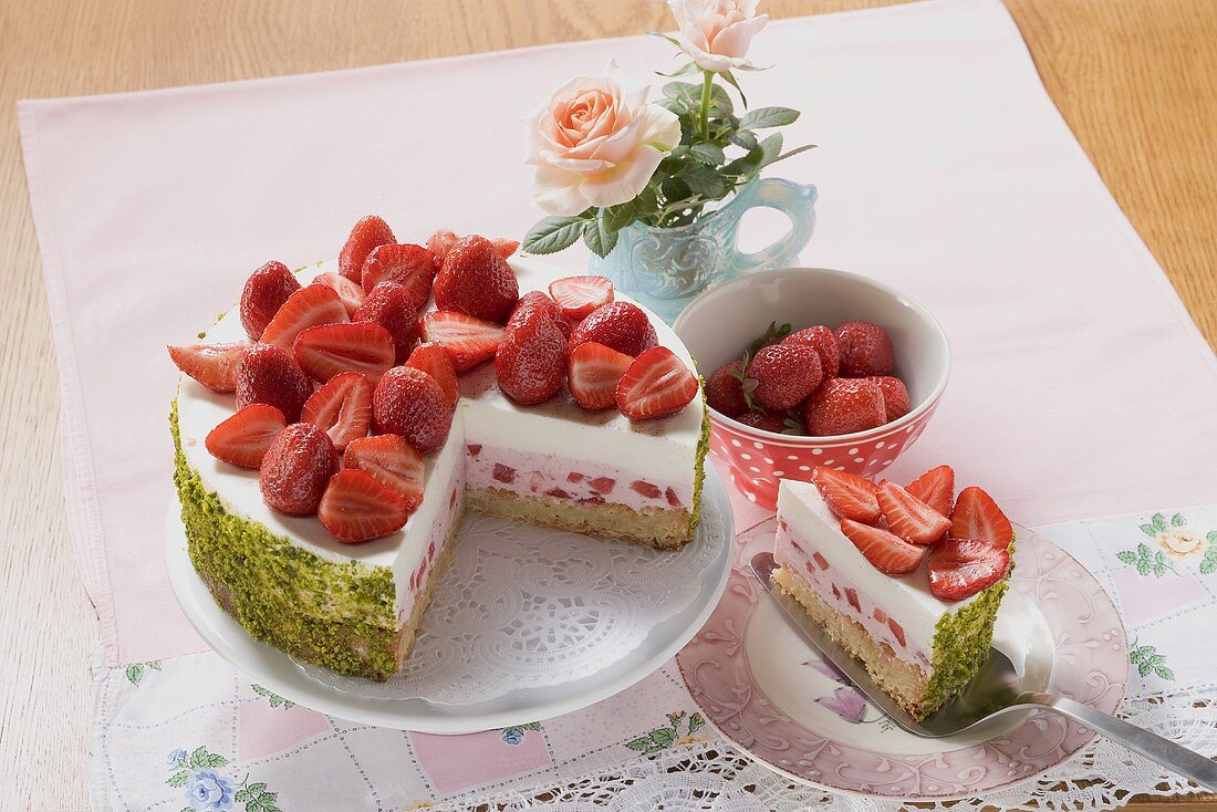 Strawberry yoghurt cake with pistachios, a piece cut