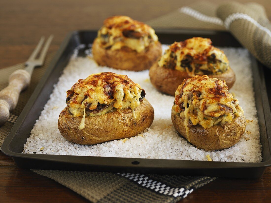 Baked potatoes on a bed of salt on a baking tray