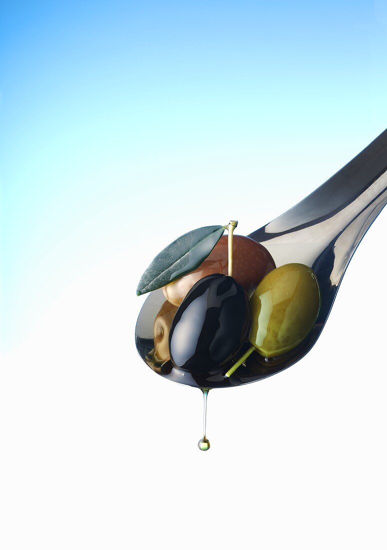 Oliven auf Löffel mit tropfendem Olivenöl