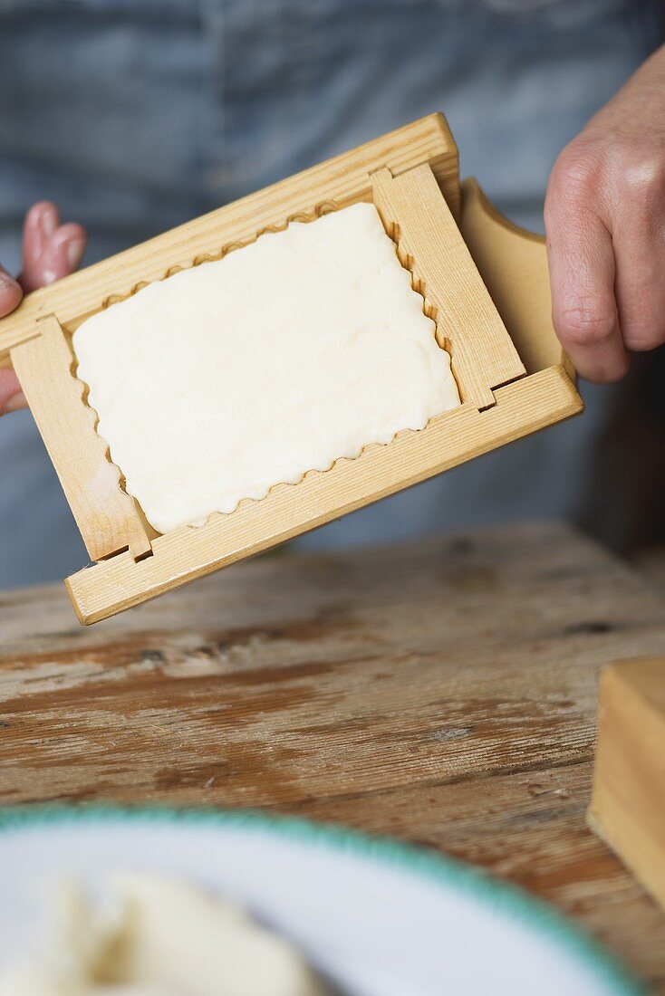 Hands holding farmhouse butter in a wooden mould