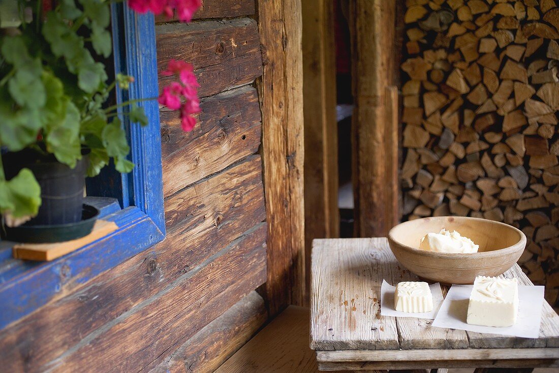 Home-made farmhouse butter on wooden table outside an Alpine chalet