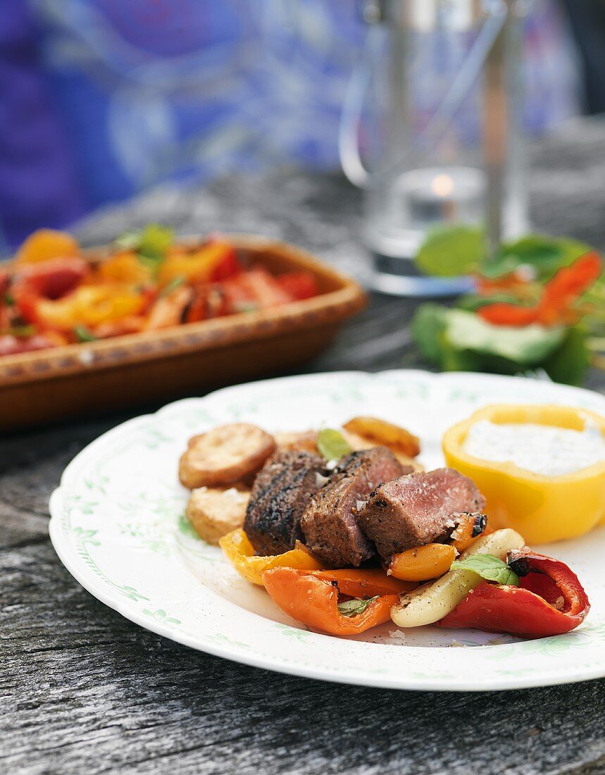 Plate of grilled meat & peppers with potatoes & tzatziki