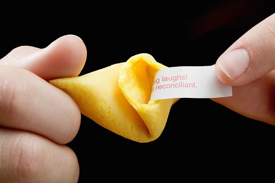 Hands holding a fortune cookie