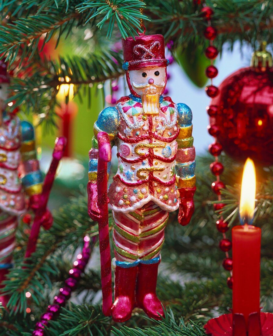 Nutcracker and burning candle on Christmas tree