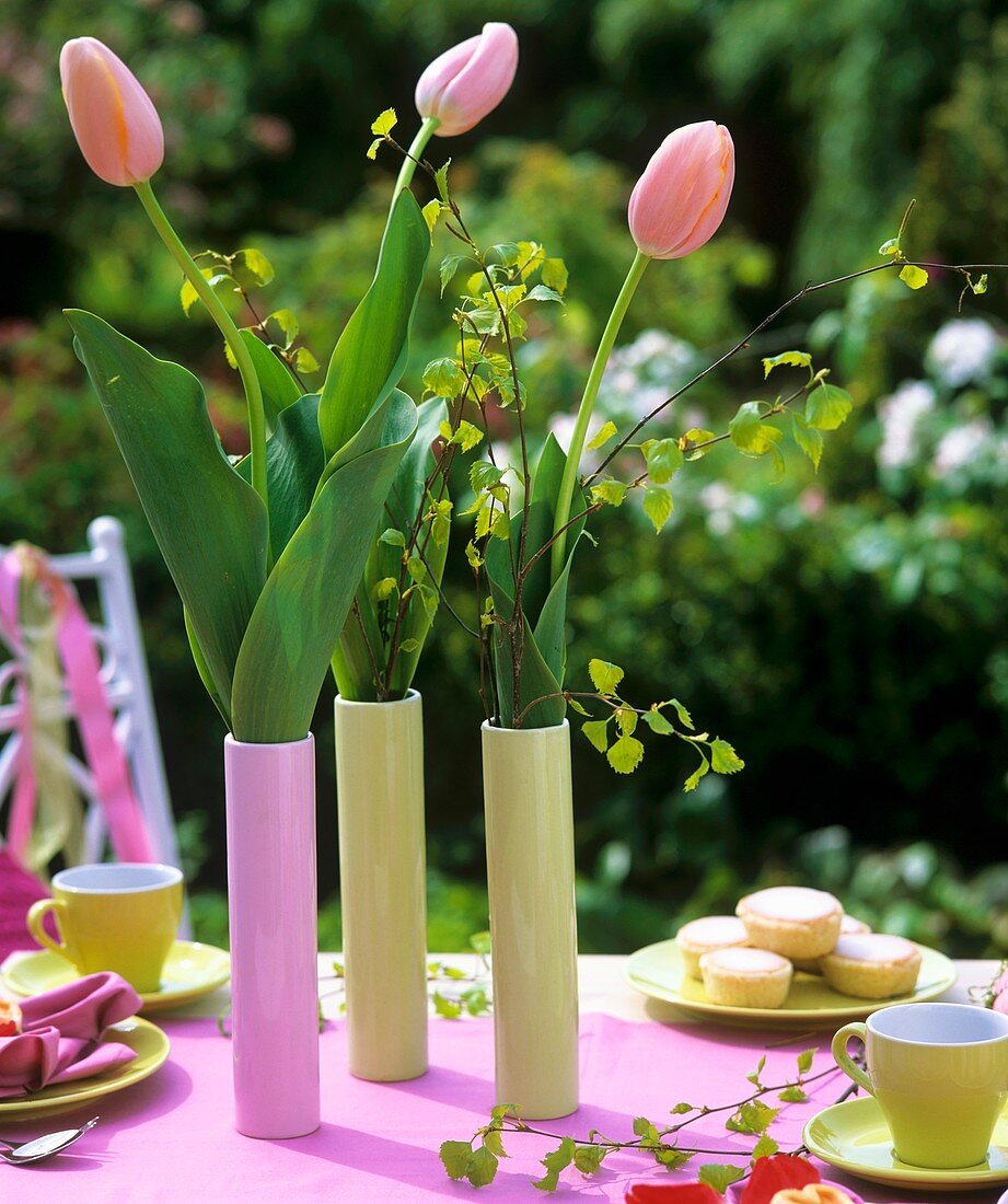 Pink tulips on table laid for coffee in open air